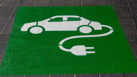 Green sign of electric car on the ground